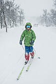 Child snowshoeing in forest