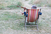 Man sitting in chair and playing guitar