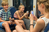 Kinder mit Smartphones im Zug