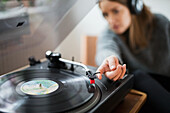 Woman with headphones listening to records