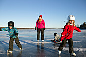 Mother with children skating on lake