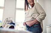 Pregnant woman getting dressed