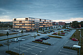 Modern residential building and parking lot at dusk