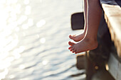 Person sitting on pier above lake