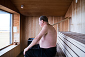 Mature man sitting in sauna