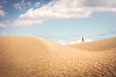Tourist walking on sand dune