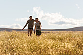 Children walking through meadow