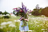 Girl holding flowers on meadow