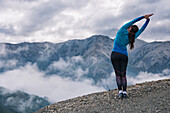 Woman stretching in mountain scenery