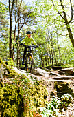 Boy cycling through forest