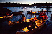 Children in canoes a summer evening.