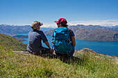 Boy with woman looking at lake in mountains