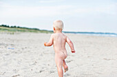 Naked toddler on beach