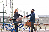 Man and woman shaking hands on street