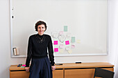 Smiling woman in front of white board