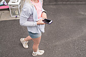 Mädchen geht mit Smartphone spazieren