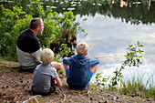 Father and sons fishing at lake