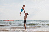 Vater spielt mit Sohn am Strand