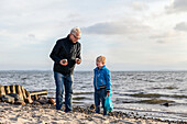 Großvater mit Enkelsohn am Strand