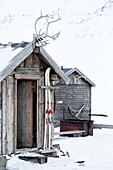 Wooden hut with skis in winter