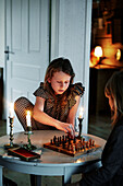 Two girls playing chess in living room