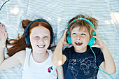 Geschwisterkinder hören Musik über Kopfhörer