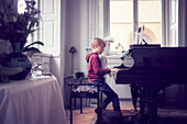 Boy playing piano in living room