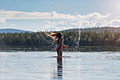 Girl tossing hair in lake