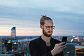 Man using smartphone in city