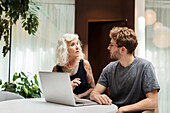 Man and woman working on laptop