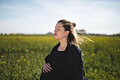 Pregnant woman contemplating in meadow