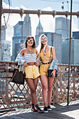 Two stylish women standing in front of skyscrapers