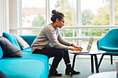 Frau mit Laptop im Wohnzimmer