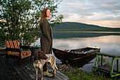 Woman with dog contemplating at seaside