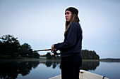 Teenage girl fishing from boat