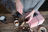 Woman pouring mulled wine while packing present