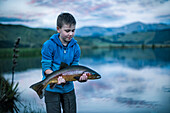Junge mit Fisch in der Hand