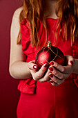 Child holding Christmas bauble, close-up