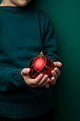 Child holding Christmas bauble, close-up