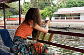 Frau auf Boot beim Fotografieren