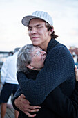 Junger Mann umarmt seine Großmutter