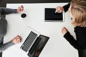 Businesswomen using laptop and digital tablet during meeting