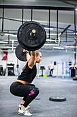 Woman lifting barbell in gym