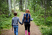 Mädchen und Junge gehen im Wald spazieren