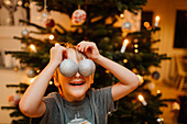 Boy playing with Christmas ornaments