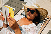 Frau liest auf einem Liegestuhl