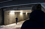 Frau betritt Tunnel bei Nacht