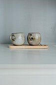 Mugs on wooden board