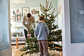 Vater und Sohn beim Schmücken des Weihnachtsbaums