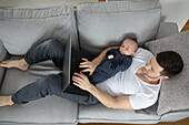 Man with baby on sofa